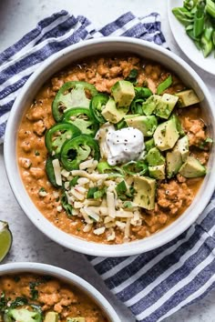 a white bowl filled with beans, avocado and sour cream on top of a striped towel