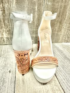 a pair of white high heeled shoes sitting on top of a wooden floor next to each other