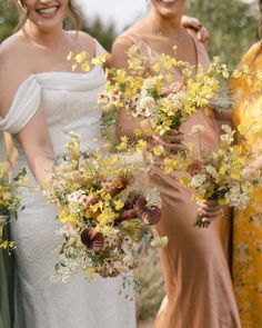 three bridesmaids holding bouquets of yellow and white flowers in their hands, smiling at the camera