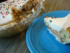 a piece of cake sitting on top of a blue plate next to a pie dish