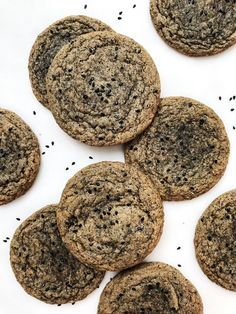 chocolate cookies with sprinkles are arranged on a white surface