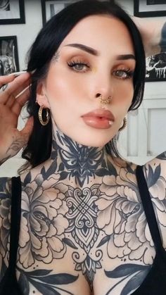 a woman with tattoos and piercings on her chest