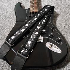 a guitar strap with stars on it sitting on top of a black electric guitar body