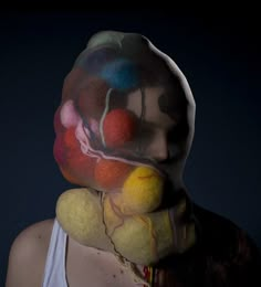 a woman with her face painted like a clown holding a teddy bear in front of her face