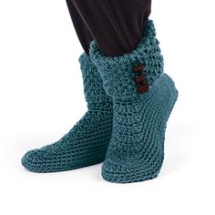 a person standing with their feet up in crocheted slippers and black pants