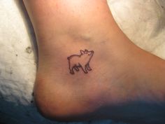 a small tattoo on the foot of a person with a bear symbol in it's center