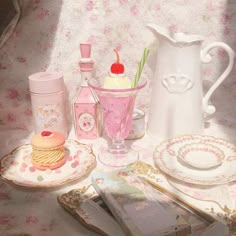 a table topped with plates and cups filled with desserts next to a pink vase