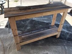 a wooden table sitting on top of a cement floor next to a fire hydrant