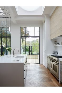 a kitchen with an oven, sink and glass doors