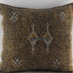 a decorative pillow with an embroidered design on the front and back, sitting on a white surface