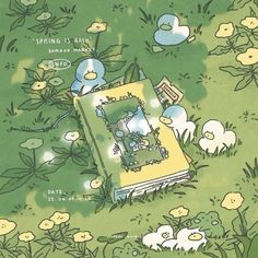 an open book sitting on top of a lush green field next to small white flowers