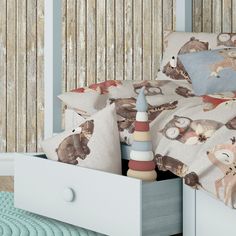 a child's bed with pillows and toys in the drawer on top of it