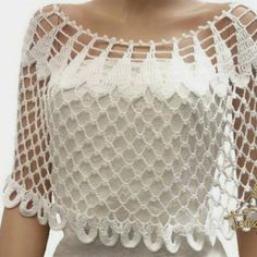 a woman wearing a white top with crochet on it