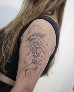 a woman's arm with a jellyfish tattoo on her left shoulder and right arm