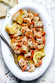 a white bowl filled with shrimp and bread