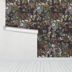 an empty room with a flowery wallpaper and wooden flooring in front of it