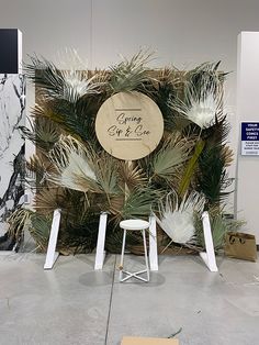 an art exhibit with palm trees and white stools in front of a sign that says going get & see