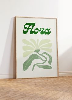 a poster with the word flora on it in front of a white wall and wooden floor