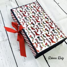 a book with christmas stockings on it and a red ribbon tied around the front cover