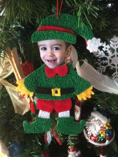 a young boy is wearing a christmas ornament