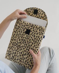 a person is holding an animal print ipad case in their left hand while sitting down