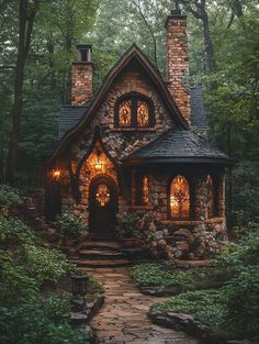 a small stone house in the woods with lights on it's windows and door