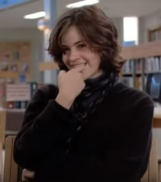 a woman sitting at a table in a library