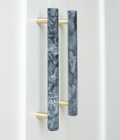 two black and white marble door handles on a white door with gold handlebars