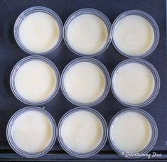 six cups filled with cream sitting on top of a cookie sheet