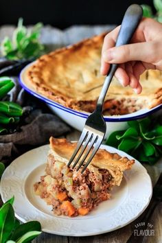 a person holding a fork over a piece of pie on a white plate with green plants in the background