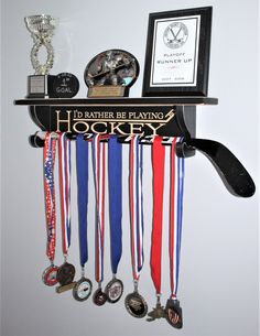 a wall mounted trophy rack with medals and other sports memorabilia on it's shelf