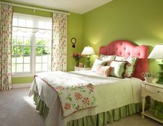 a bedroom with green walls and pink headboard, white bedding, and floral curtains