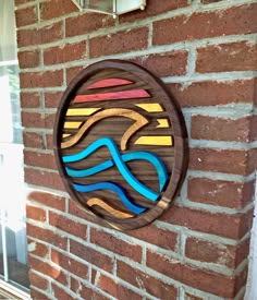 a wooden sign on the side of a brick building that has a river painted on it