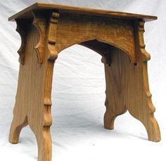 a small wooden stool made out of wood with an arch at the top and bottom