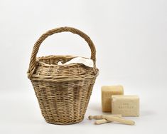 a wicker basket with soap and two wooden shavings next to it on a white background