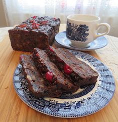 two pieces of chocolate cake on a blue and white plate next to a coffee cup