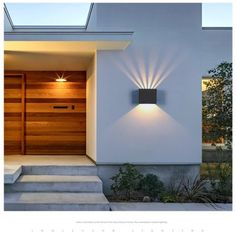 an image of a modern house with lights on the front door and steps leading up to it