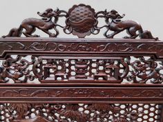 an intricately carved wooden piece with animals on it