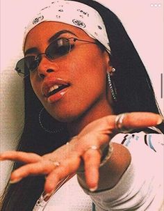 a woman pointing at the camera with her hand in front of her and wearing sunglasses