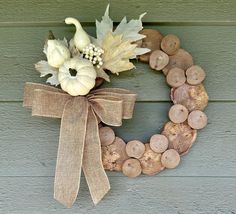 a wreath made out of wood slices and pumpkins