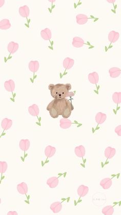 a teddy bear sitting on top of a pink flowered wallpaper with green leaves