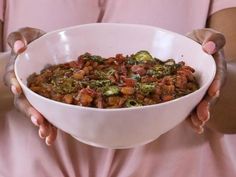 a person holding a bowl full of food