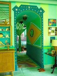 a room with green walls and blue flooring, decorated in gold trimmings