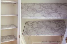 an empty pantry with marble shelves in it