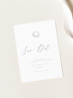 a white wedding card with a seashell on it