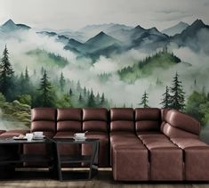 a living room with a couch, coffee table and wall mural on the wall behind it