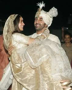 a man in a turban carrying a woman on his back at an event