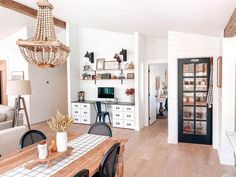 a living room filled with furniture and a chandelier hanging over the top of it