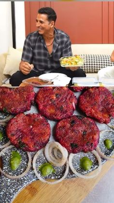 two men are sitting at a table with food on it and one man is eating