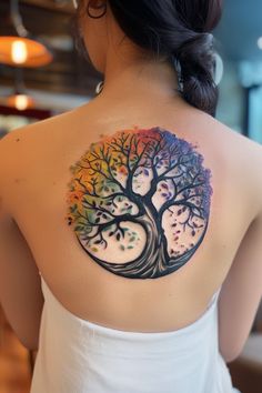 a woman with a colorful tree tattoo on her back shoulder and upper half of her body